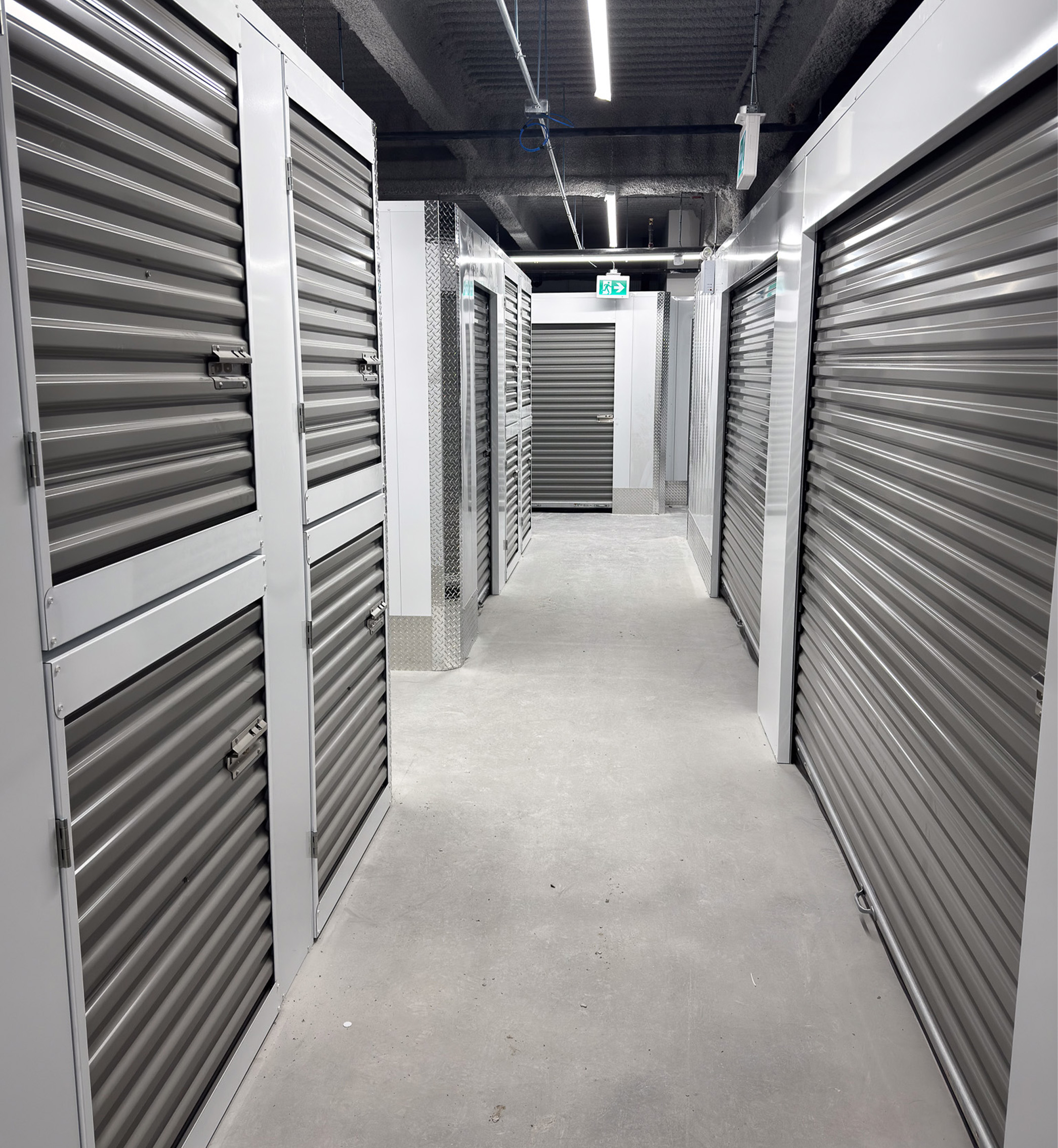 Self-storage corridor with grey corrugated partitions and unit doors
